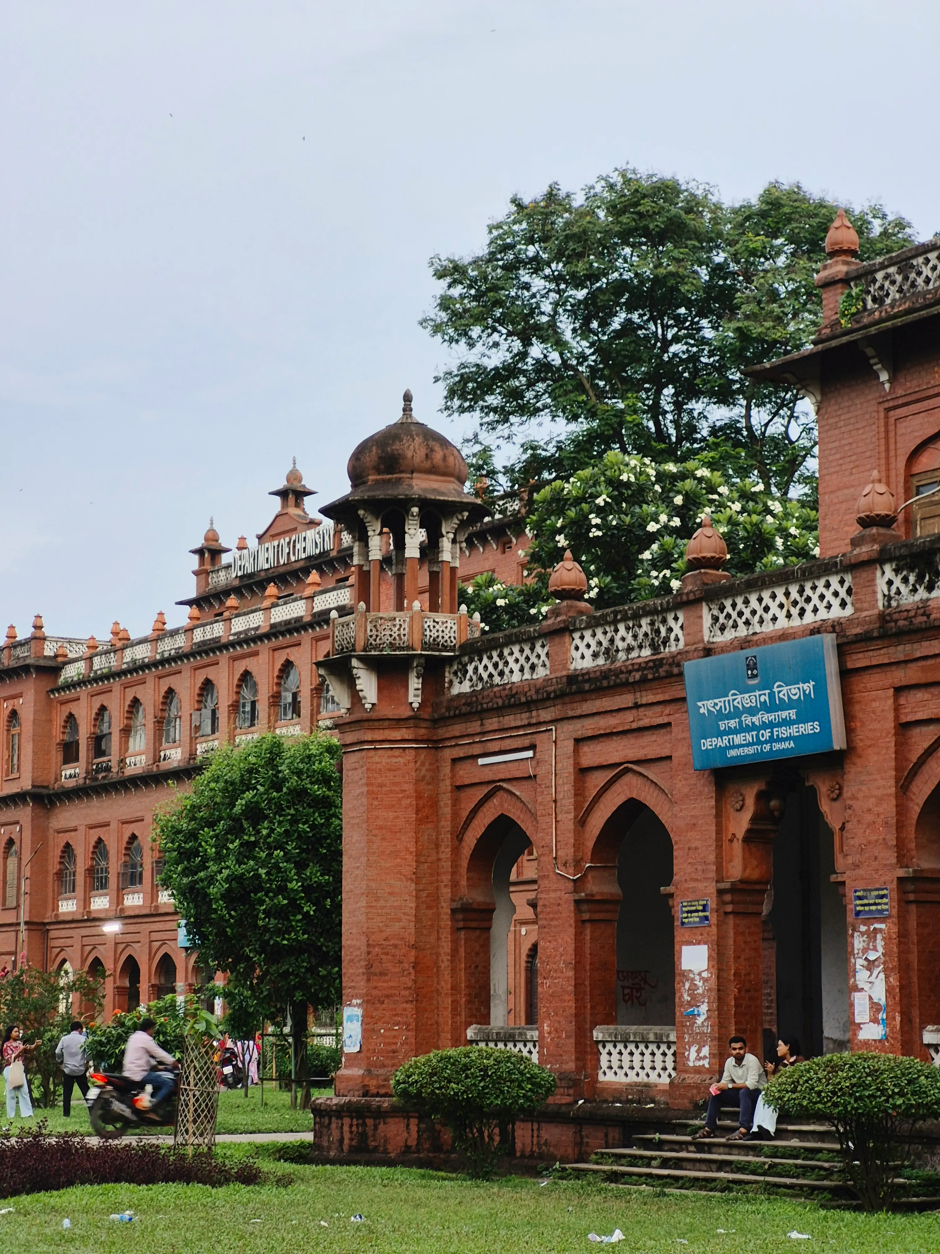 A historic red brick building with ornate architecture on a university campus